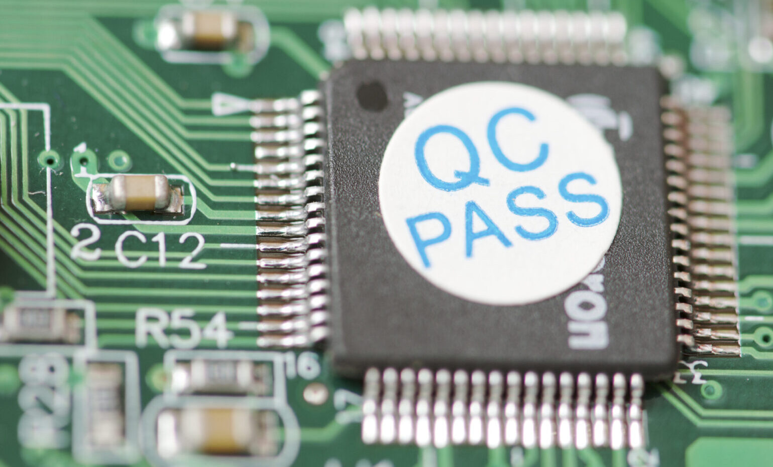 detail of an integrated circuit with a sticker of "quality control" detail of an integrated circuit